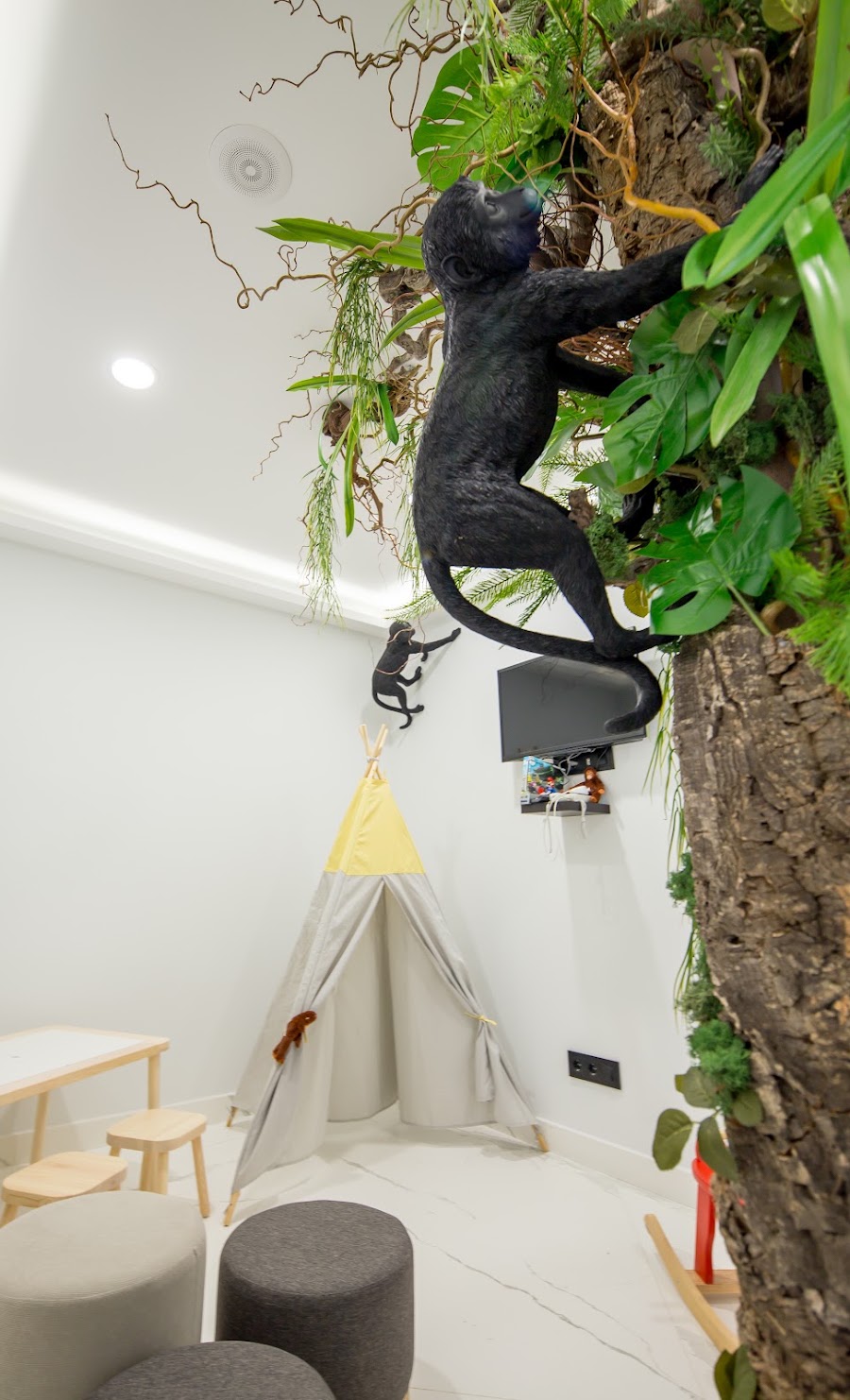Árbol decorativo de jungla con figura de mono en la zona infantil